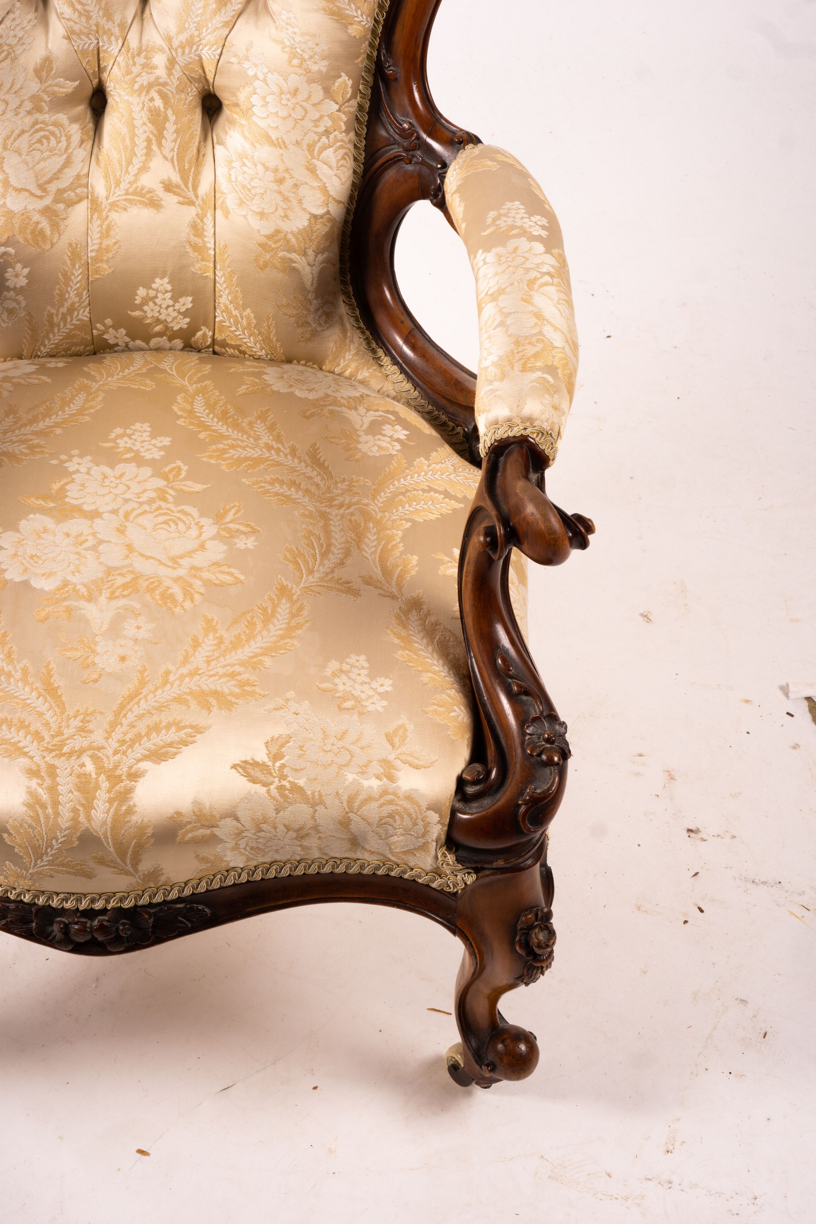 A late Victorian carved walnut three piece salon suite, comprising chaise longue, open armchair and nursing chair